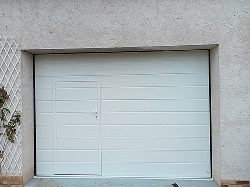 Porte de garage blanche et treilles sur le mur